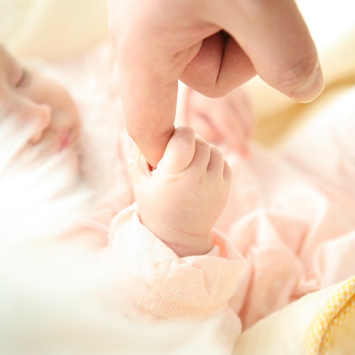 baby holding parent's finger